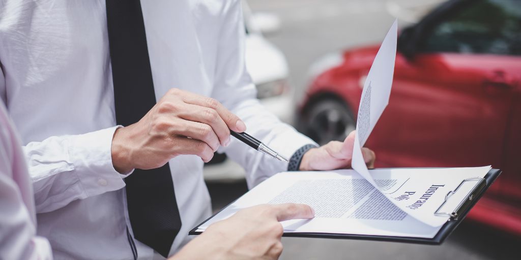 Two Men with Clipboard Reviewing Car Insurance Policy